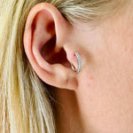 A model wearing Juraster’s 9ct White Gold Diamond Hoop Earring, Anchor, crafted from Fairmined white gold and conflict-free diamonds, in her tragus.