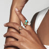 A model wearing Juraster’s 9ct Gold Diamond-Shape Ring, Compass, crafted from Fairmined 9ct yellow gold. She also wears three yellow gold rings, one chrysoprase, one turquoise and one rainbow moonstone.