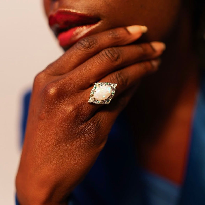 A model wearing Juraster’s versatile 14ct white gold transformable ring-pendant with opal, rainbow gemstones & diamonds, Selkie 2, crafted from Fairmined white gold, precious Australian opal, hand-cut gemstones and conflict-free diamonds.