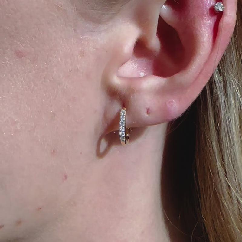 A video of a model wearing Juraster’s 9ct Gold Diamond Hoop Earring, Anchor, crafted from Fairmined yellow gold and conflict-free diamonds along with a yellow gold diamond stud in her cartilage.