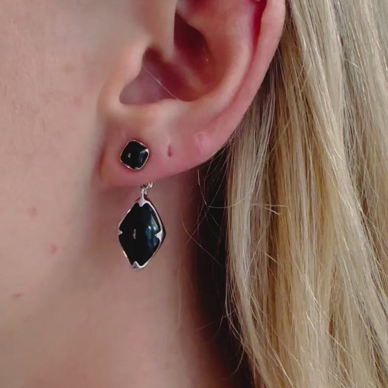 A video of a model wearing Juraster's Sterling Silver Black Onyx Earring Charm, Adventure, crafted from Fairmined sterling silver and hand-cut black onyx, with a matching earring charm attached.