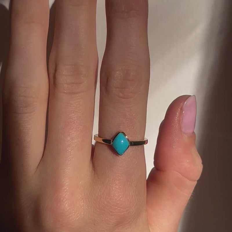 A video of a model wearing Juraster’s 9ct Gold Stacking Ring in Persian Blue Turquoise, Lodestone, crafted from Fairmined 9ct yellow gold and a hand-cut turquoise gemstone.